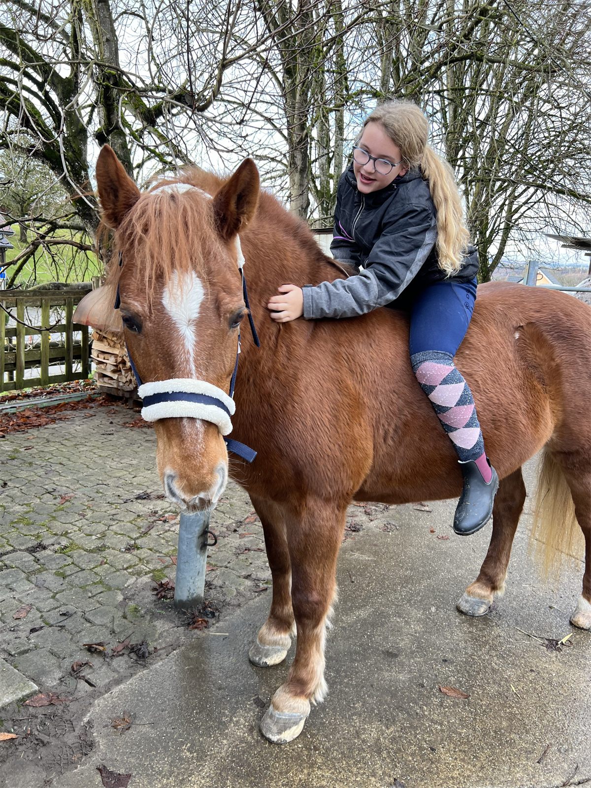 Giulia auf dem Pony im Winter