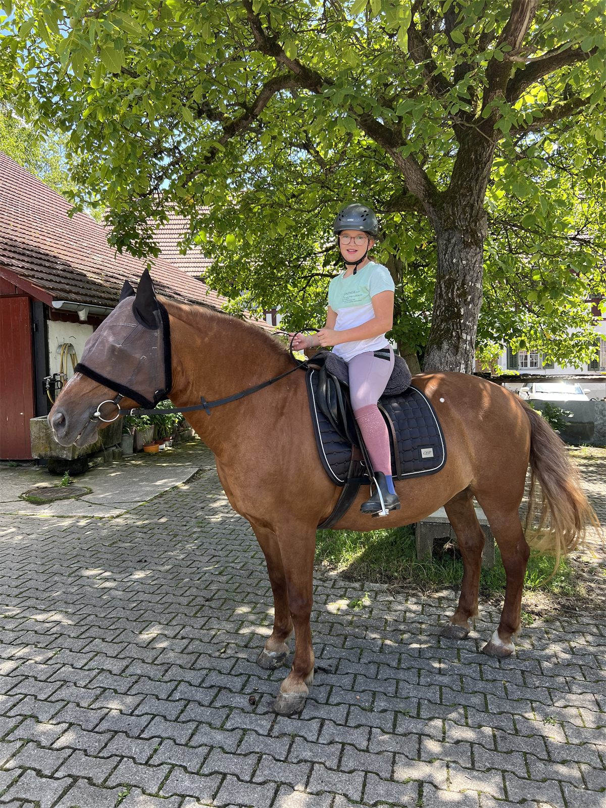 Giulia zu Pferd auf dem Hof